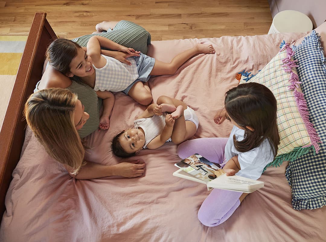 Family reading a book on the bed