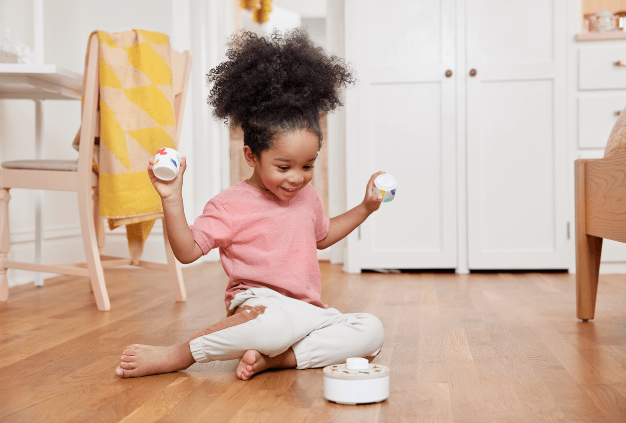 Child playing with the Loud & Quiet Stackable Shakers from The Music Set by Lovevery